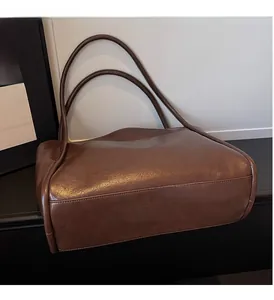 Dettaglio di una borsa tote vintage marrone scuro con trama in similpelle liscia e cuciture