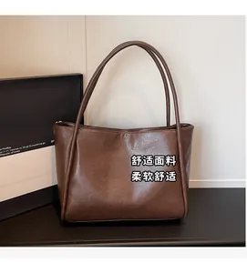 Dettaglio borsa tote vintage marrone con trama cerata e sottili spalline lunghe