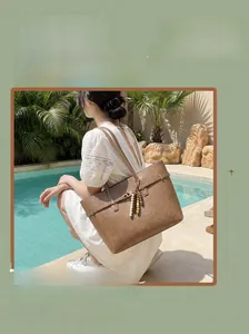 Brown large capacity tote bag with bohemian bead charm shown by a poolside