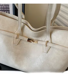 Detail shot of the cream PU leather tote with premium gold hardware buckle and fine texture