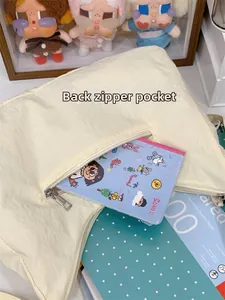 Vue détaillée de la poche arrière zippée dissimulée sur un sac fourre-tout plissé beige
