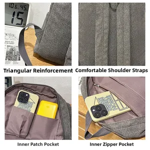 Detail view of reinforced straps and internal storage compartments of gray backpack
