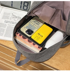 Detailed interior of a grey canvas backpack showing multiple pockets and large storage space