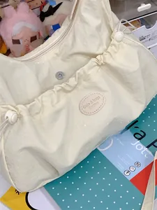 Détail du cabas en nylon avec poche avant magnétique à cordon et bandoulière
