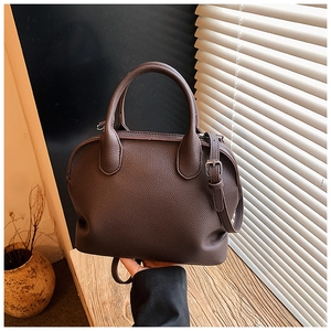 Detail of lychee textured dark brown shell bag with silver hardware and adjustable strap