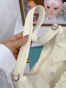 Détail du sac cabas en nylon crème avec large poignée, coutures et fermoir magnétique
