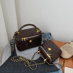 Deep brown quilted leather crossbody box bag set with gold floral clasp and chain strap