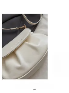 Détail du sac selle blanc crème froncé avec lettrage gravé et fermoir en métal doré