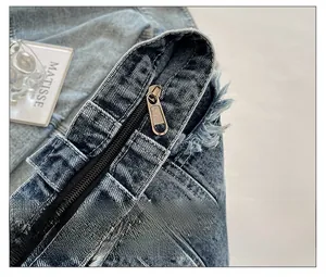 Macro detail of the smooth black zipper and copper puller on washed denim tote bag
