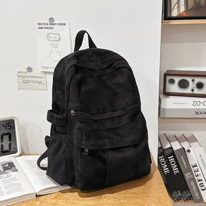 Detail view of the black retro canvas backpack with textured fabric and side pockets