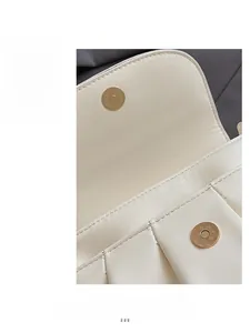 Détail du sac crème avec un fermoir magnétique doré rond et des coutures de précision