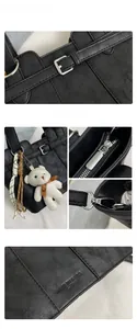 Details einer schwarzen strukturierten Tasche mit Silberbeschlägen und Plüschbär-Anhänger