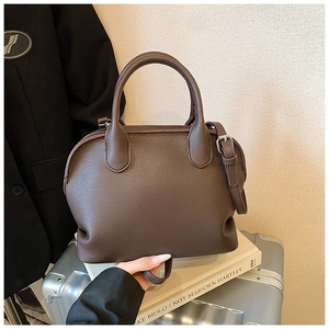 Detail of dark brown lychee pattern leather shell bag with adjustable shoulder strap