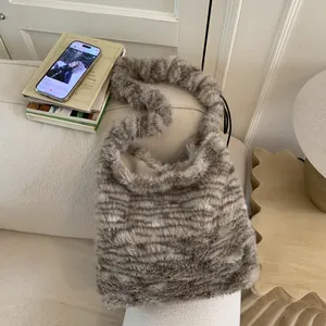 Detail of soft leopard faux fur shoulder bag texture placed on a cream fabric sofa