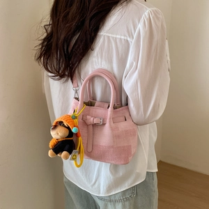 Detail der rosa Canvas-Beuteltasche mit süßem Plüsch-Hundeanhänger und Gurt