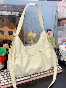Détail du sac cabas en nylon crème avec poches à cordon et fermeture à glissière