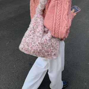 Outdoor shot of a pink leopard plush tote bag showing soft faux fur texture