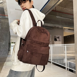 Close-up of brown canvas backpack with suede texture and metal zipper details