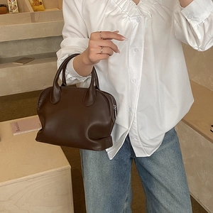 Deep brown shell-style handbag with double handles and metal zipper detail