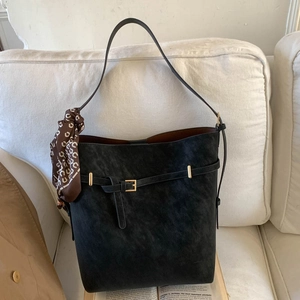 Macro view of black matte tote bag featuring gold buckle detail and printed silk scarf