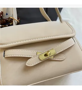 Detailed close-up of a beige faux leather bag featuring a gold twist-lock metal closure