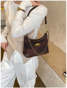 Detail view of vintage dark brown crossbody bag with textured canvas and gold chain