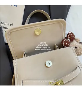 Detail of beige PU bag showing strong magnetic closure and cute plush bear charm