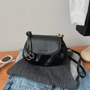 Detail of black pleated crossbody bag with gold ring and Fashion & Bags embossing