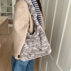 Detail of plush leopard print shoulder bag showing faux fur texture and wide strap