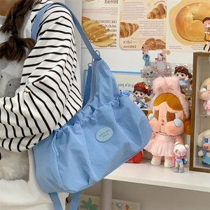 Détail du sac boule en nylon bleu clair avec plis à cordon et étiquette de mode mignonne