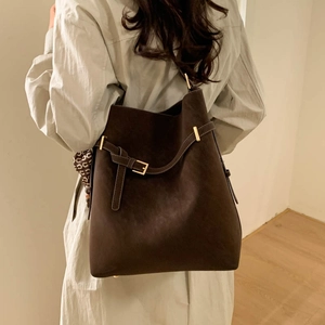 Detail of vintage dark brown tote bag featuring gold hardware and wraparound belt accent