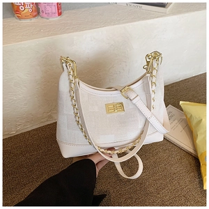 Detail view of cream jacquard half-moon bag featuring a gold chain and turn-lock
