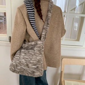 Detailed back view of a grey and white striped plush faux fur shoulder bag
