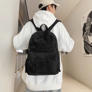 Detailed view of black suede backpack with wide shoulder straps on a male model
