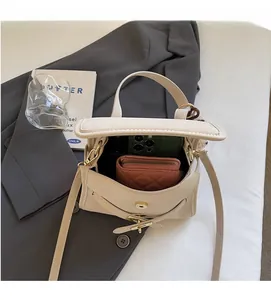Top view of cream white shoulder bag interior with wallet and phone for storage detail