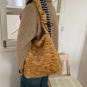 Detailed texture of leopard faux fur shoulder bag with soft plush finish and strap