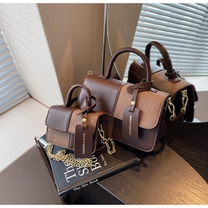 Detail of vintage patchwork handbags in brown tones with golden chain straps and tags