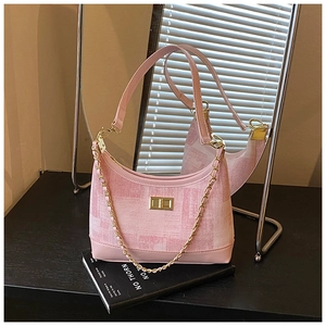 Detailed view of pink chain crossbody bag featuring textured fabric and gold turn-lock