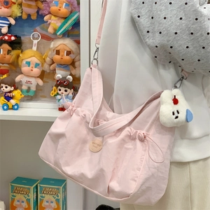 Détail du sac croissant rose plissé avec texture nylon et breloque lapin en peluche