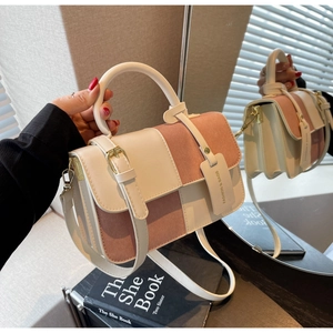 Detail view of two-tone crossbody bag with smooth leather and suede texture contrast