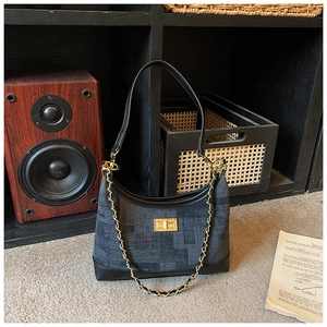 Detail of vintage textured fabric hobo bag with gold chain strap and metal clasp