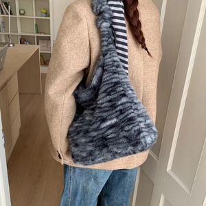 Detailed view of plush leopard print shoulder bag with soft grey and black faux fur texture