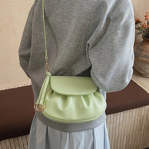 Detail of mint green pleated square bag with Fashion & Bags embossing and gold rings