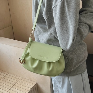 Detail view of mint green pleated square crossbody bag with gold hardware and strap