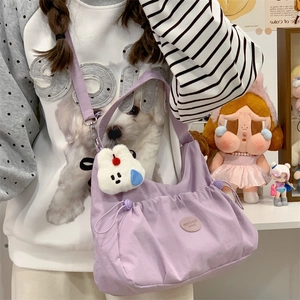 Détail du sac fourre-tout lavande avec breloque lapin en peluche et écusson de marque