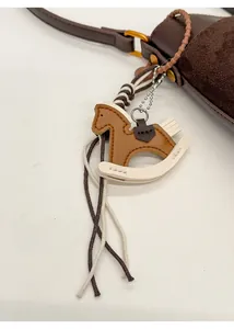 Detailed close-up of leather horse bag charm with exquisite braided rope and metal chain