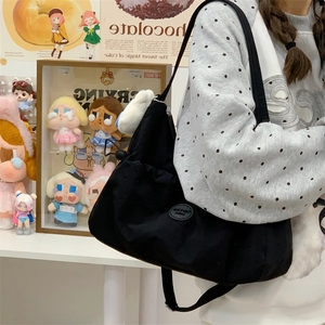 Vue détaillée du sac bandoulière en nylon noir avec cordon de serrage et logo