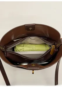 Internal view of brown leather bucket bag showing compartments and daily essentials capacity
