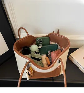 Dettaglio di una borsa tote a contrasto che mostra la grande capacità per oggetti quotidiani