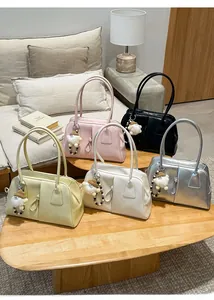 Detail of five multi-colored stylish shoulder bags with cute charms on wooden table